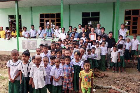 Commemorative photo with children at a completed school